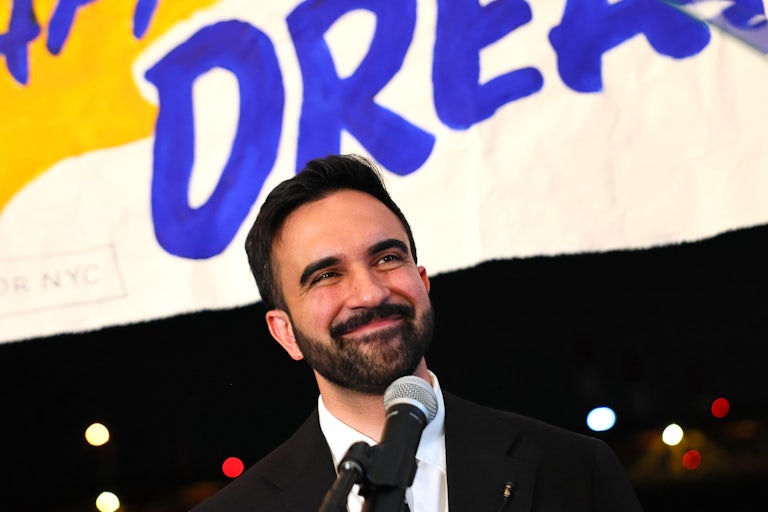 New York City mayoral candidate Zohran Mamdani smiles while standing on stage during his primary victory speech