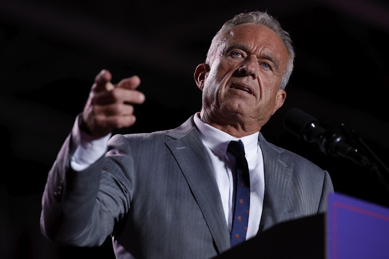 Robert F. Kennedy Jr. speaks and points while standing at a lectern during a Trump campaign rally.