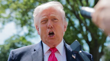 Donald Trump speaking into a mic.