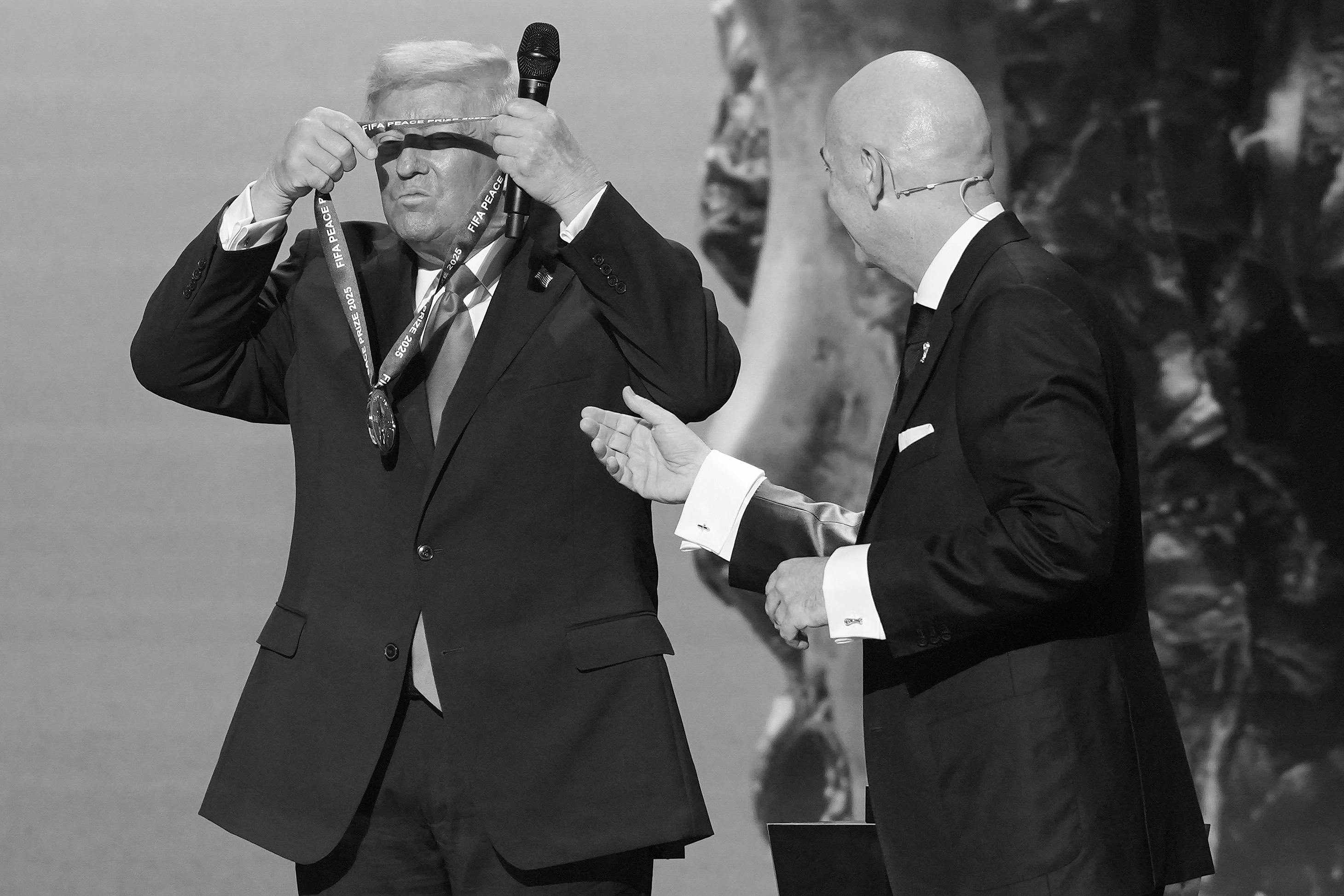 U.S. President Donald Trump places a medal from FIFA around his neck after receiving it from FIFA President Gianni Infantino 
