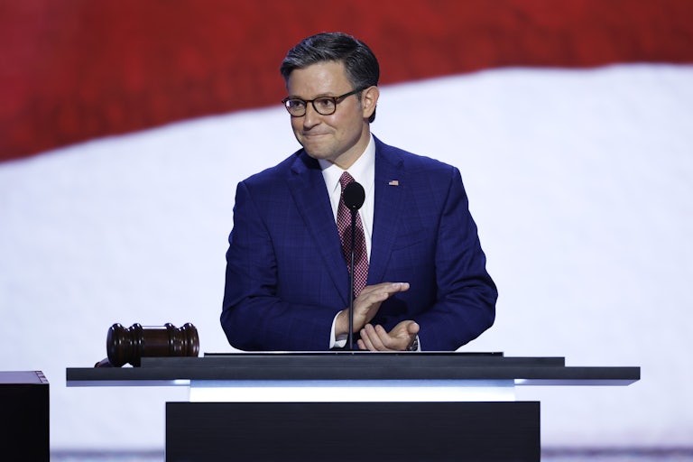 Mike Johnson claps while standing on stage at the Republican National Convention