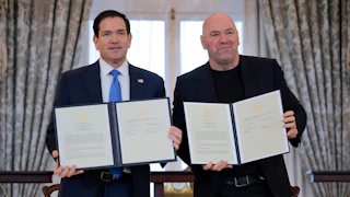 Secretary of State Marco Rubio and Ultimate Fighting Championship CEO Dana White stand next to each other smiling and holding up two copies of a signed memorandum of understanding.