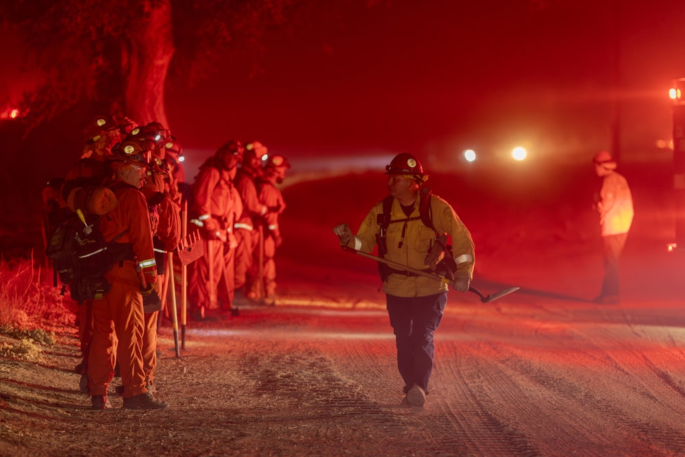 A CalFire firefighter led incarcerated firefighters who, using only hand tools and chain saws, prepared to cut a barrier against a January blaze in Los Angeles County.