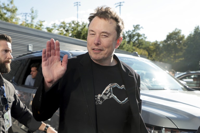 Elon Musk smiles and waves to the camera