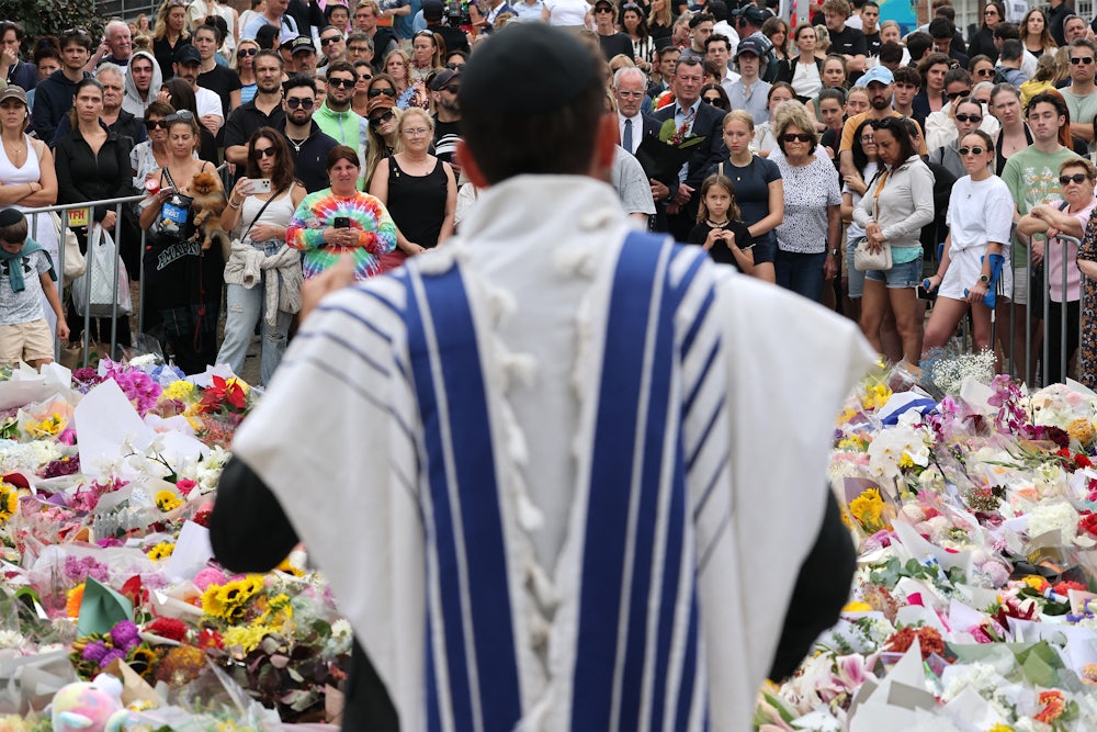 A rabbi speaks with mourners at a tribute outside Bondi Pavilion in Sydney