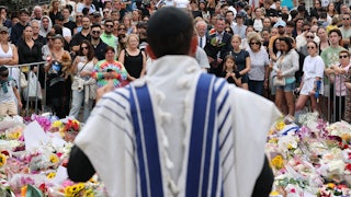A rabbi speaks with mourners at a tribute outside Bondi Pavilion in Sydney