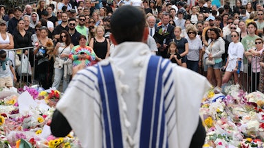 A rabbi speaks with mourners at a tribute outside Bondi Pavilion in Sydney
