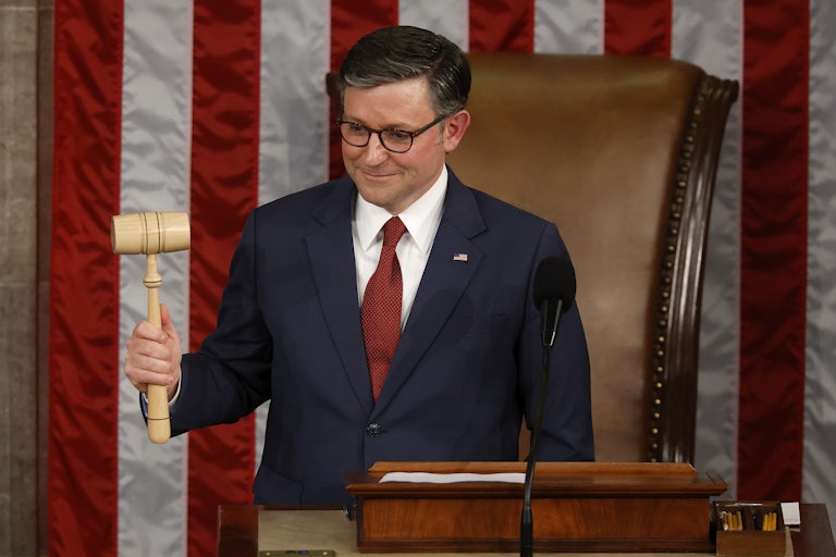 Mike Johnson raises the gavel and smiles in the Capitol