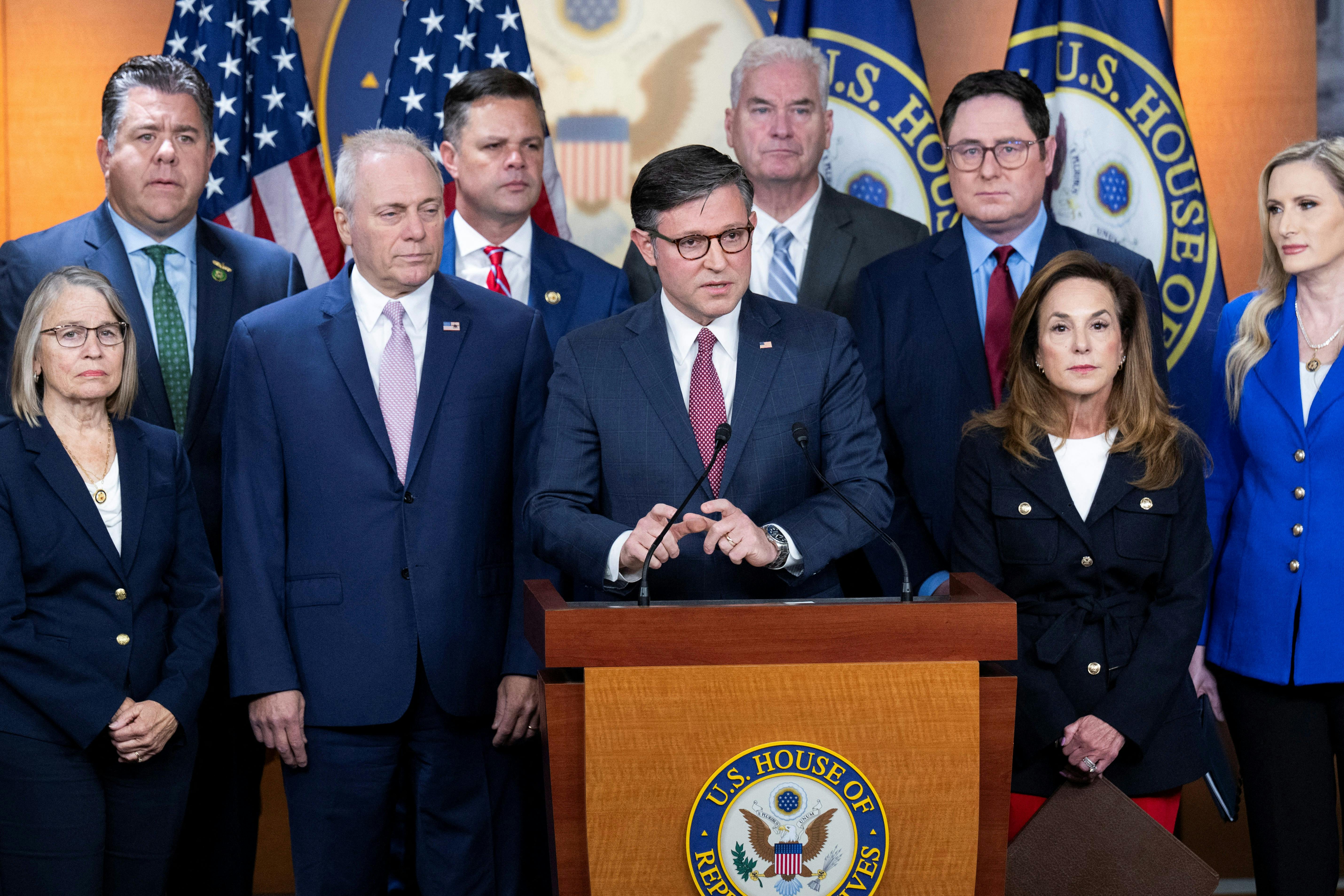 House Speaker Mike Johnson speaks at a podium while flanked by other Republican representatives