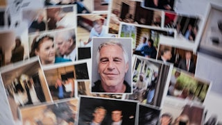 Unredacted photos of Jeffrey Epstein released by the Department of Justice spread on a table.
