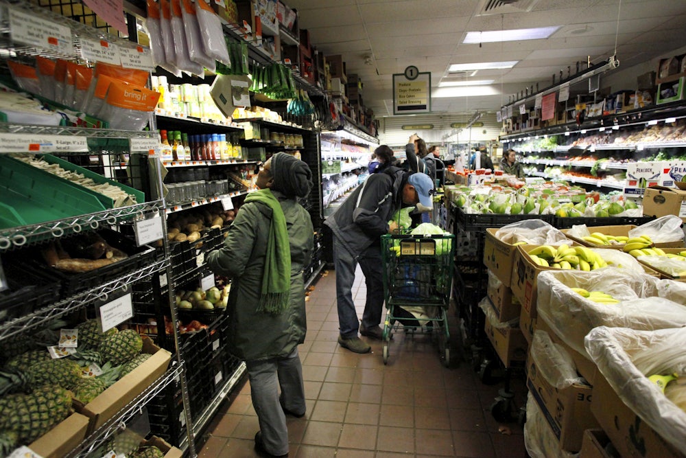 People stand in aisles stocked with food and beverages.