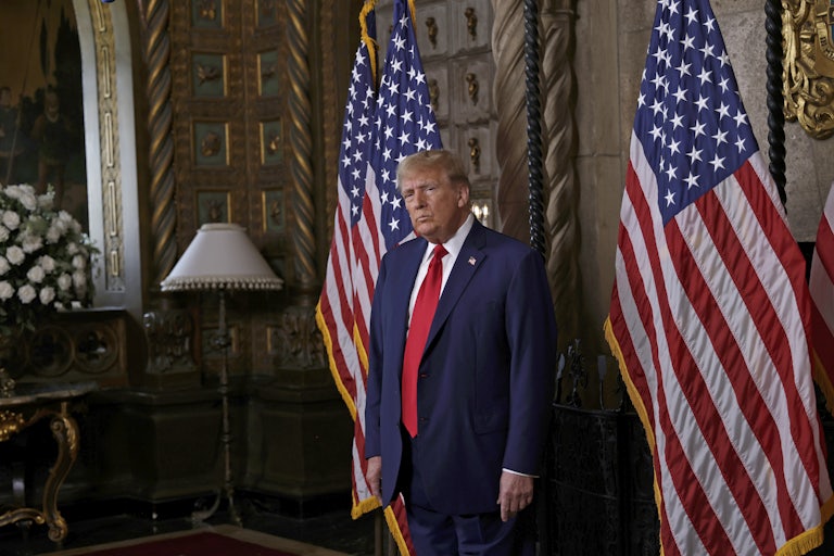 Trump stands in front of two U.S. flags