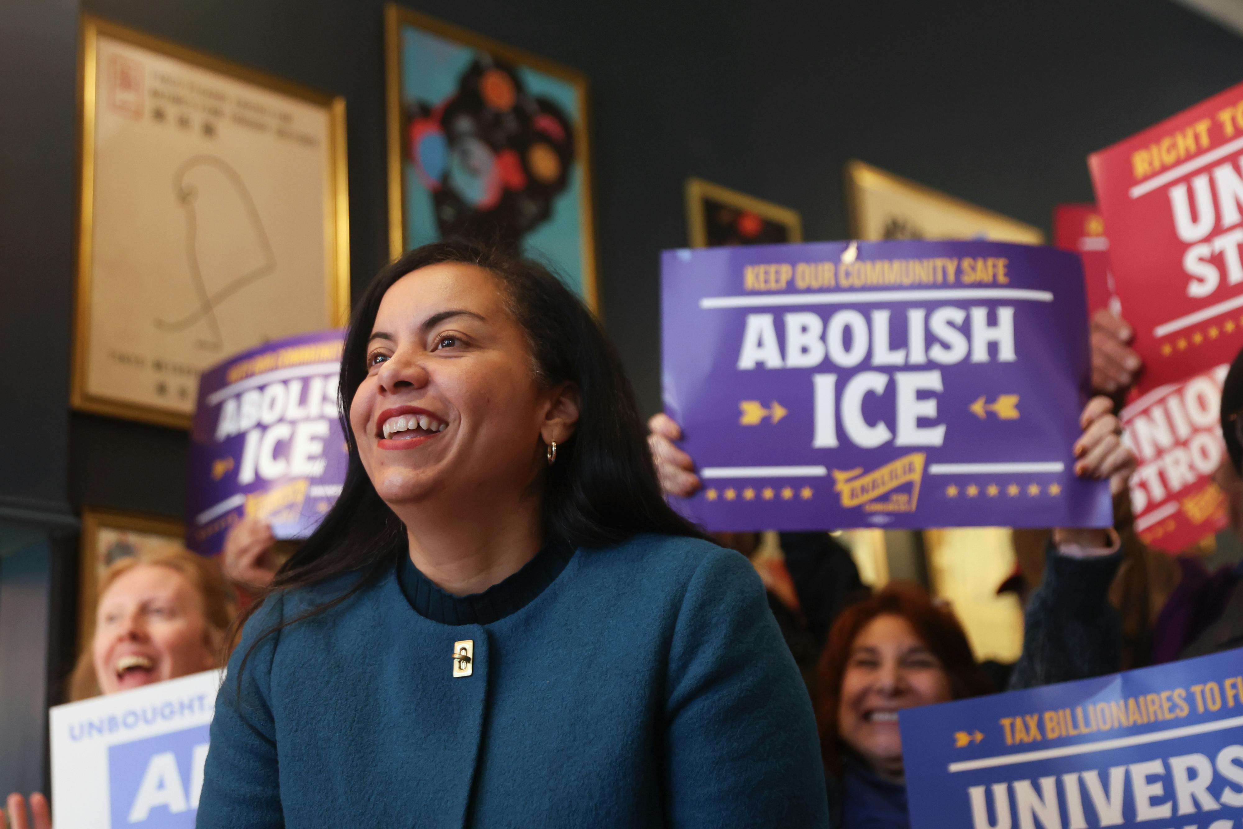 Analilia Mejia, Democratic House candidate for New Jersey, smiles as supporters behind her hold signs that read "Abolish ICE."