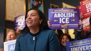 Analilia Mejia, Democratic House candidate for New Jersey, smiles as supporters behind her hold signs that read "Abolish ICE."