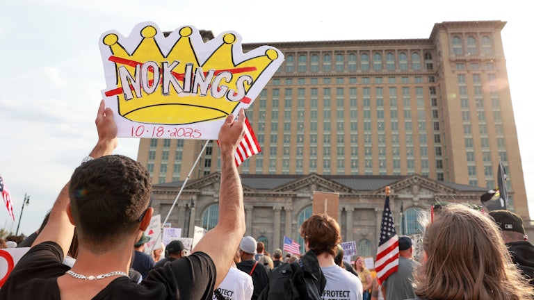 Protestors gather with signs and flags in a late afternoon No Kings 2.0 protest against the Trump Administration near Roosevelt Park in Detroit, Michigan.