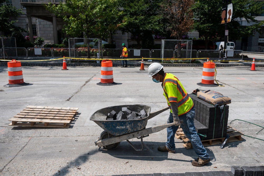 Construction workers repairs a street near the White House, in Washington, DC.