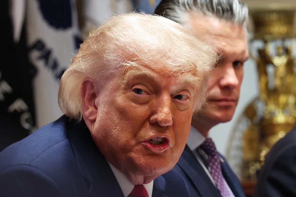 Donald Trump grimaces in wide-eyed expression while looking to his right
