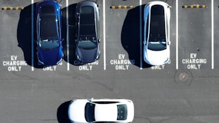 An aerial view of cars pulling in and out of an EV charging lot.