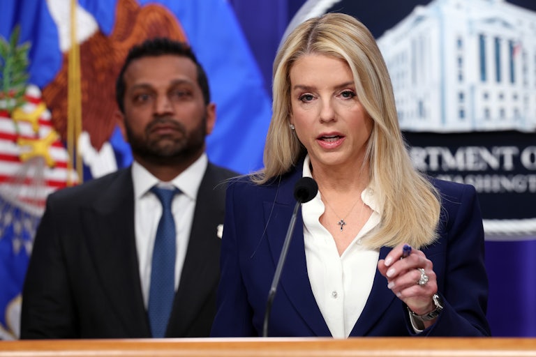 Attorney General Pam Bondi speaksk at a podium while FBI Director Kash Patel stands in the background