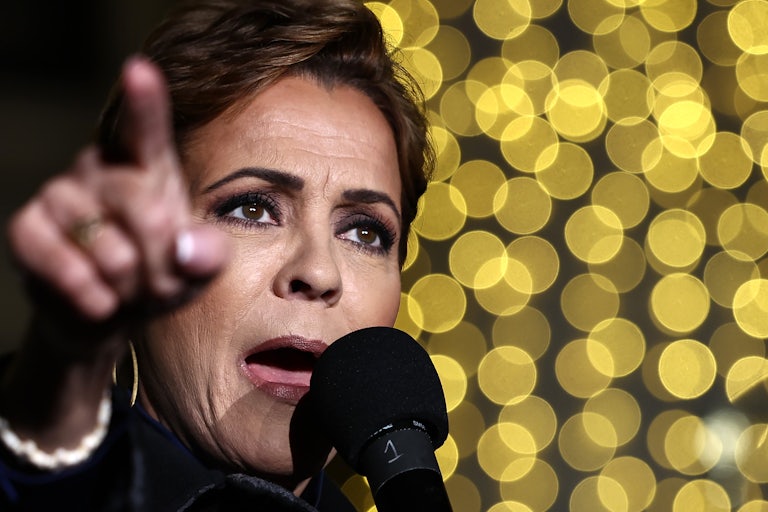 Kari Lake points while speaking into a microphone