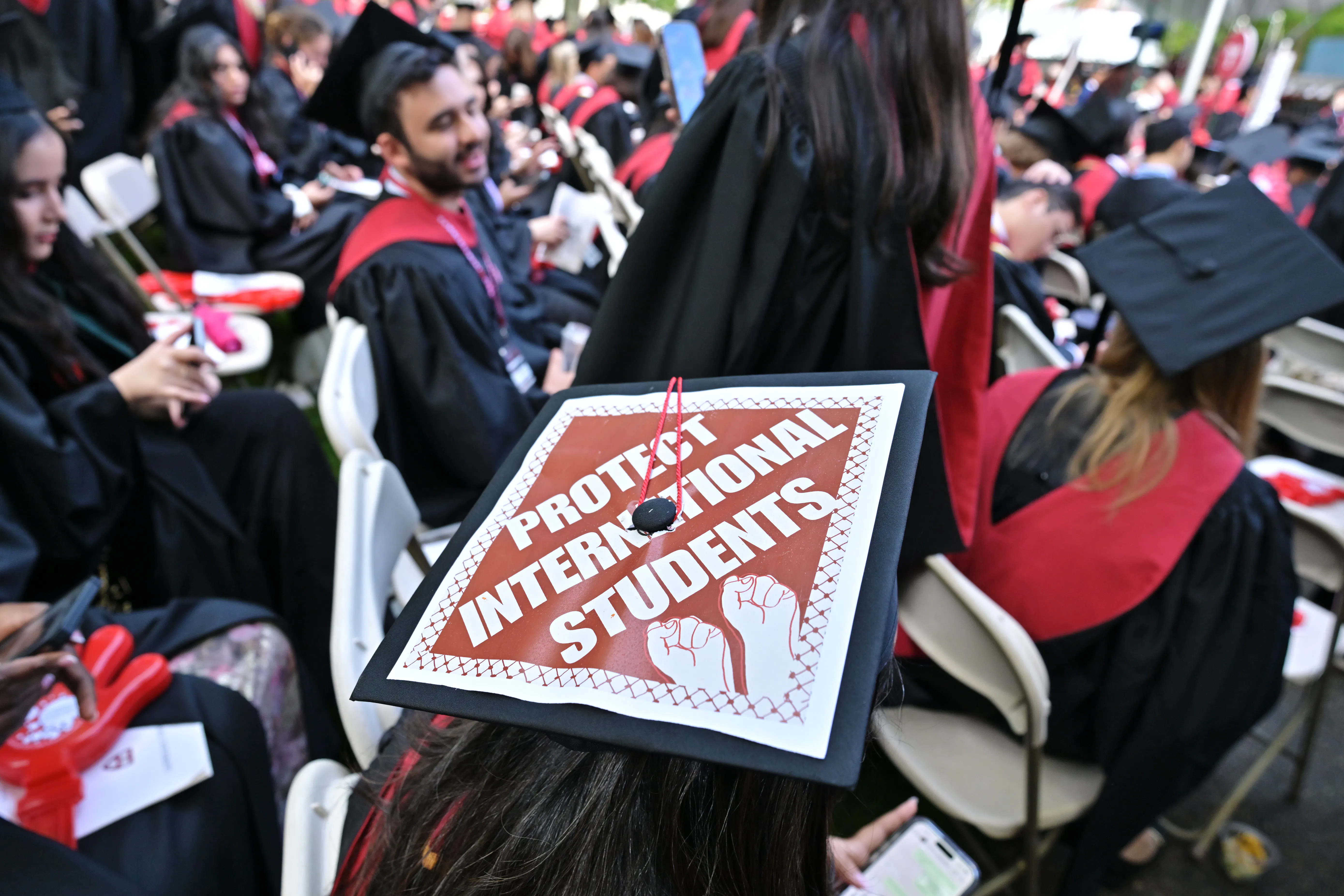 A graudation cap that says "protect international students."