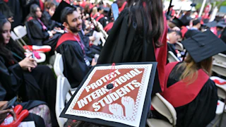 A graudation cap that says "protect international students."