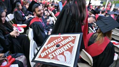 A graudation cap that says "protect international students."