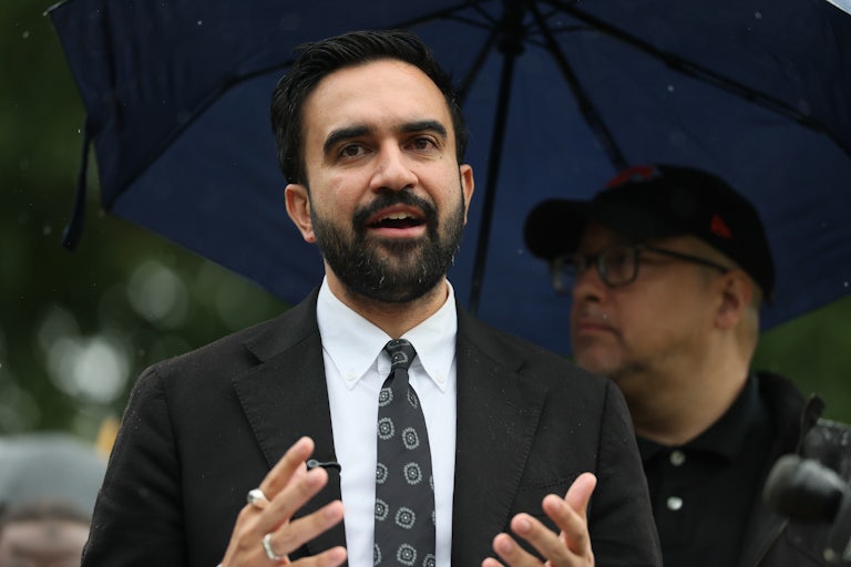 Zohran Mamdani speaks in the rain to reporters.