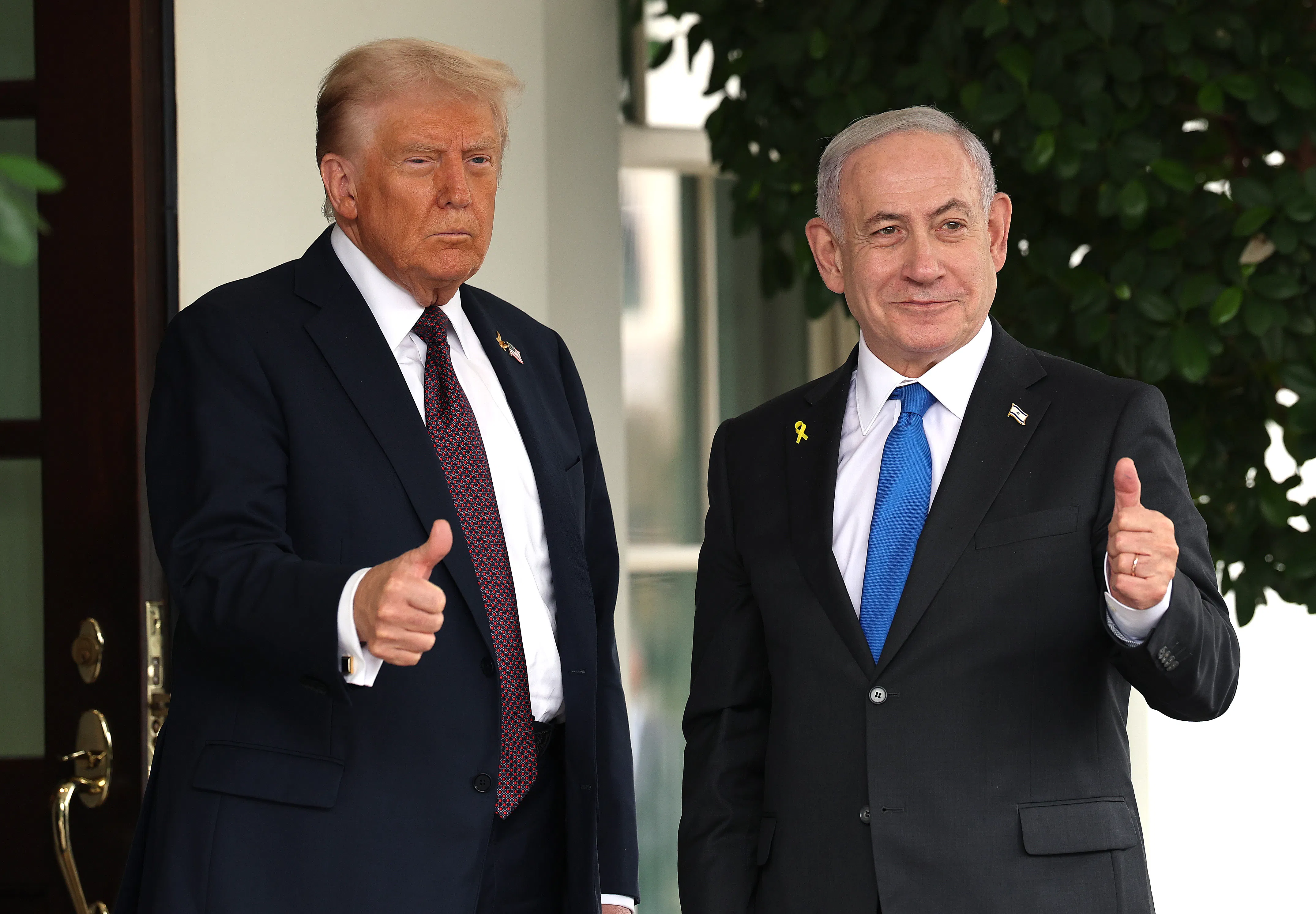 President Donald Trump and Israeli Prime Minister Benjamin Netanyahu both hold up thumbs up signs outside the White House.