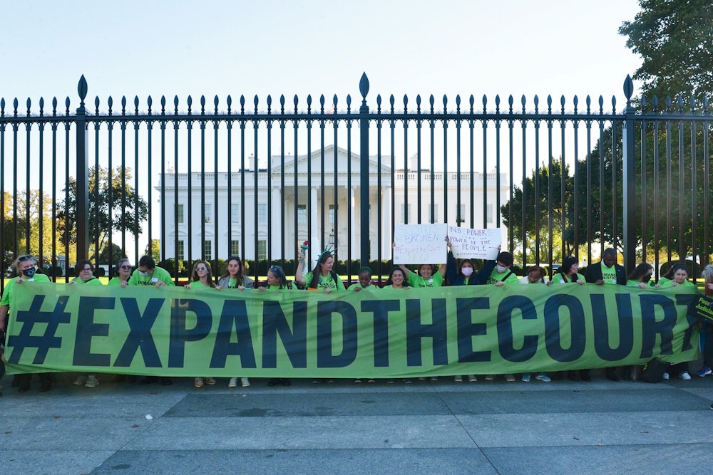Volunteers with Demand Justice rally for seats to be added to the Supreme Court outside of the White House.