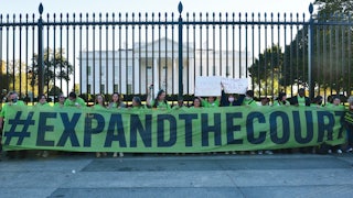 Volunteers with Demand Justice rally for seats to be added to the Supreme Court outside of the White House.