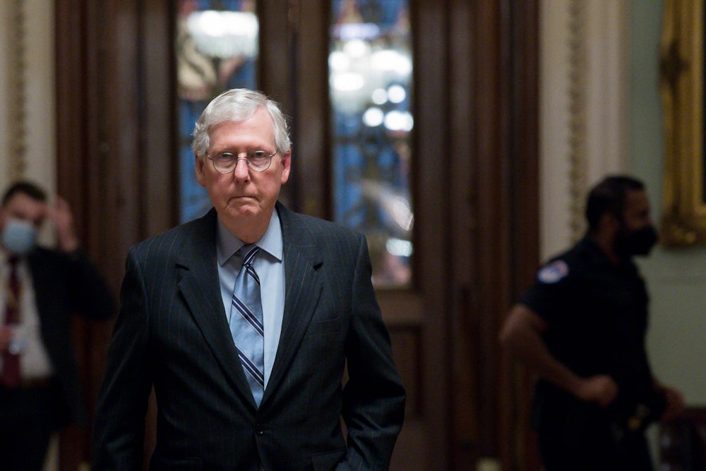 Senator Mitch McConnell walks down a hallway of the U.S. Capitol.