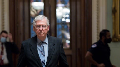 Senator Mitch McConnell walks down a hallway of the U.S. Capitol.