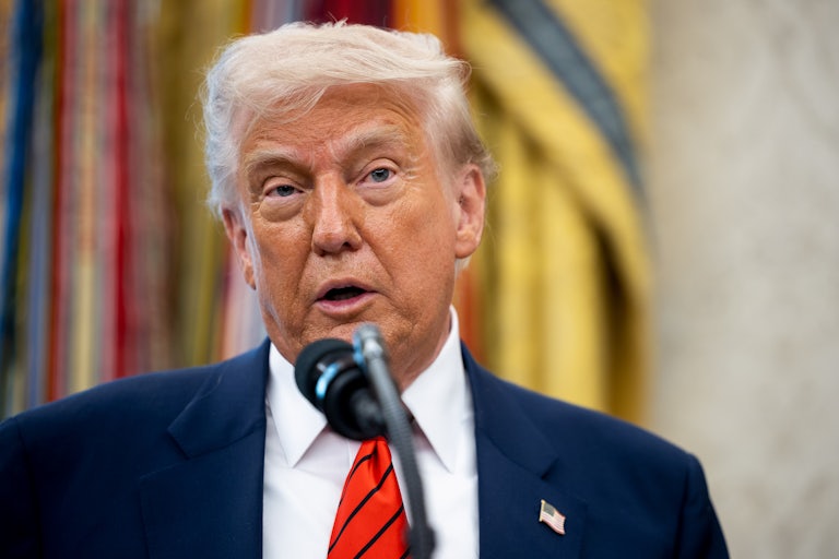 Donald Trump speaks into a microphone in the Oval Office