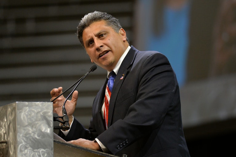 Greg Lopez speaks at a podium and makes a hand gesture, brows furrowed