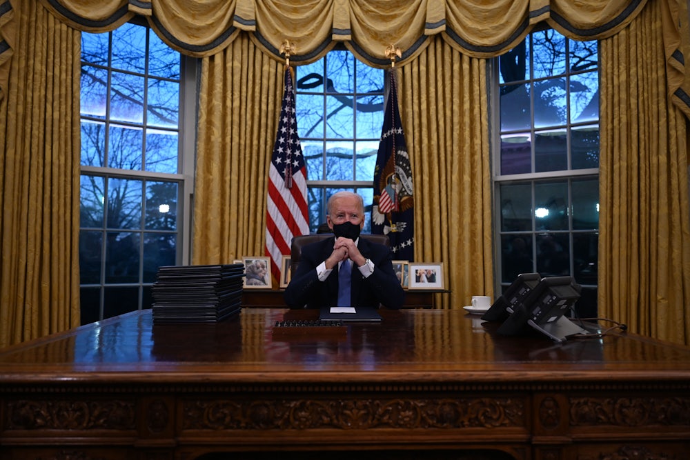 President Joe Biden sits behind his desk in the Oval Office.