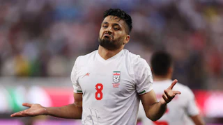 Iranian midfielder Mohammed Mohebbi holds out his arms to celebrate a goal