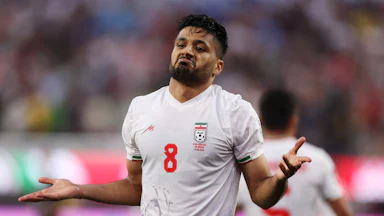 Iranian midfielder Mohammed Mohebbi holds out his arms to celebrate a goal
