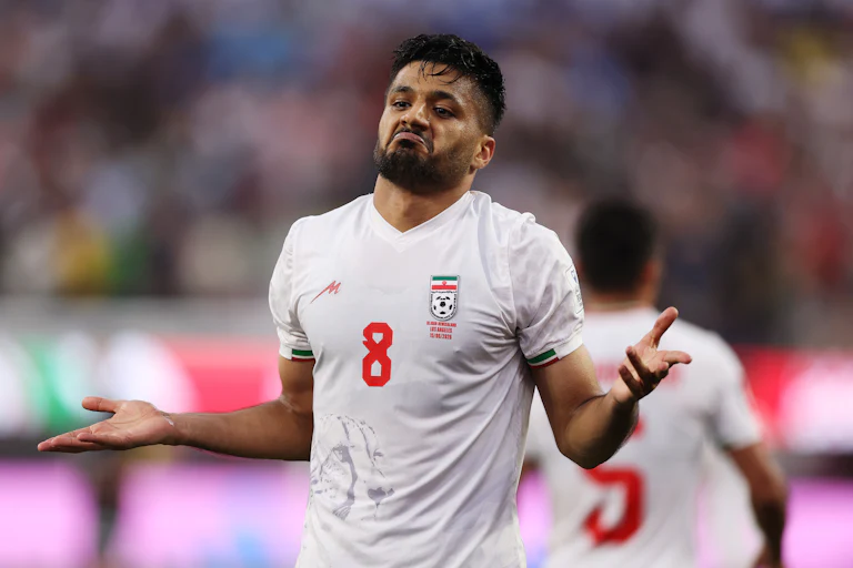 Iranian midfielder Mohammed Mohebbi holds out his arms to celebrate a goal