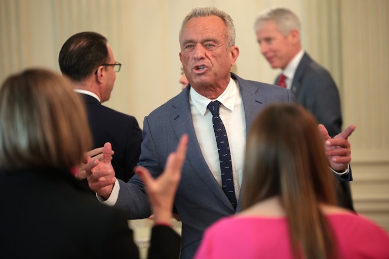 RFK Jr. speaks to two women animatedly while makng hand gestures.