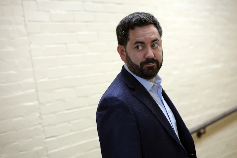 Mike Lawler looks back as he walks down a hallway in the Capitol