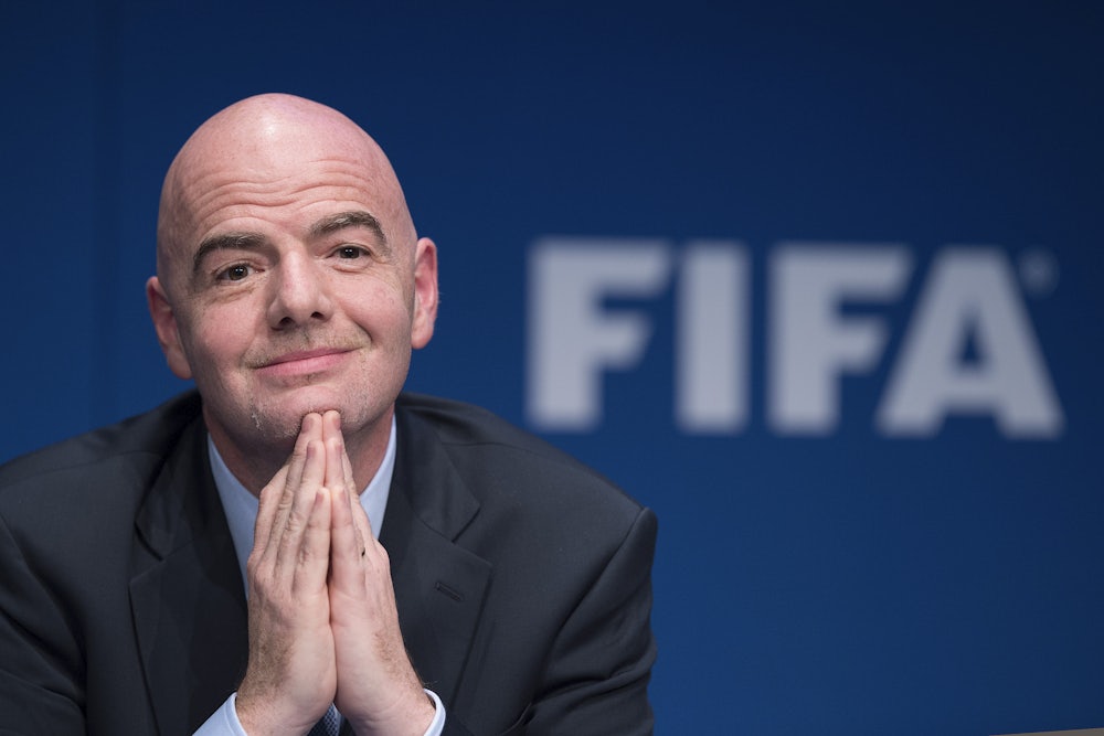 FIFA leader Gianni Infantino clasps his hands together and smiles.