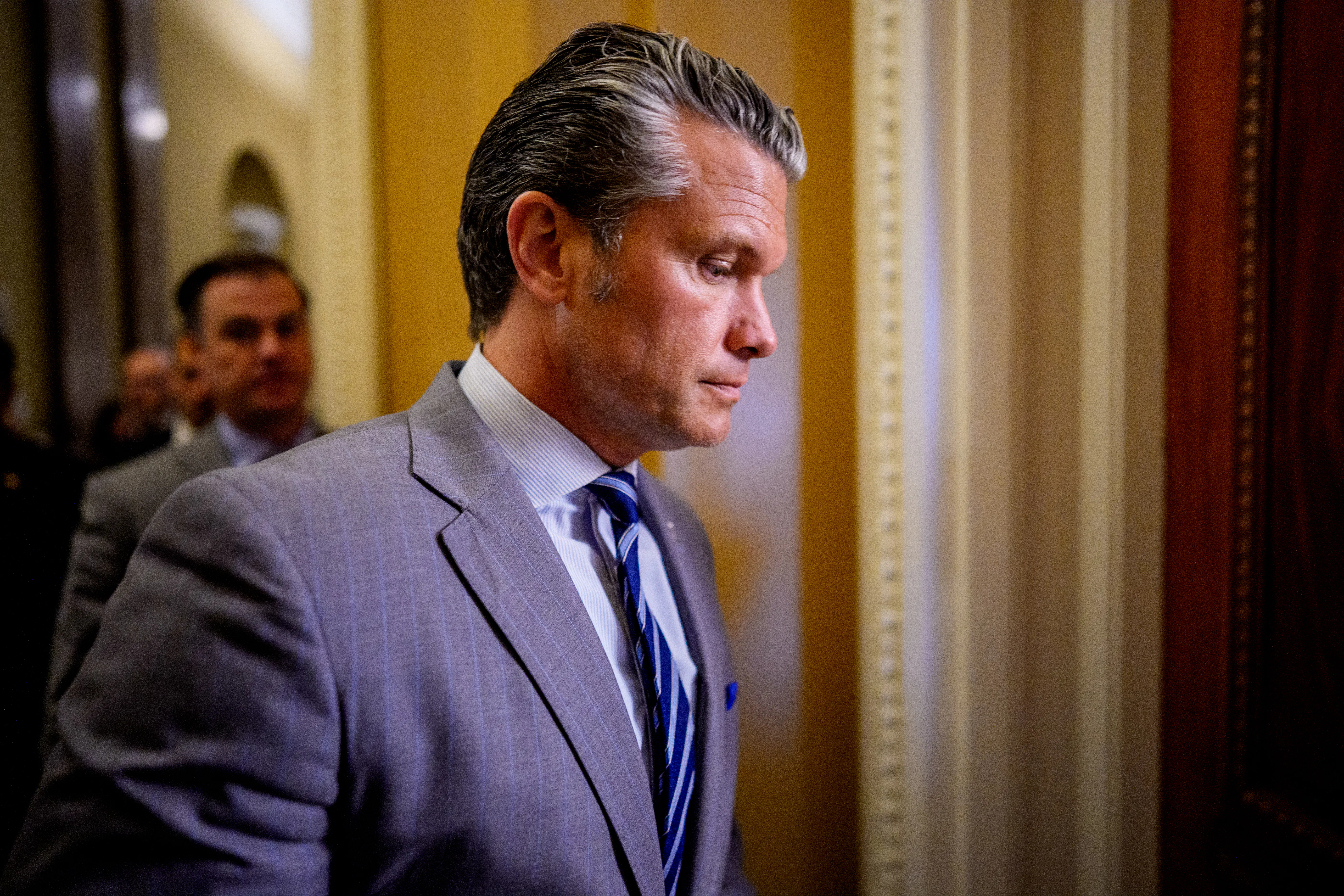 Defense Secretary Pete Hegseth looks down while walking in the Capitol