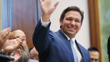 A smiling Ron DeSantis waves to a crowd.