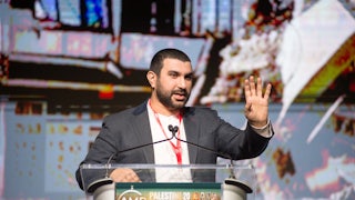 Sami Hamdi speaks at a lectern that “reads Palestine Convention 2024 Gaza.”