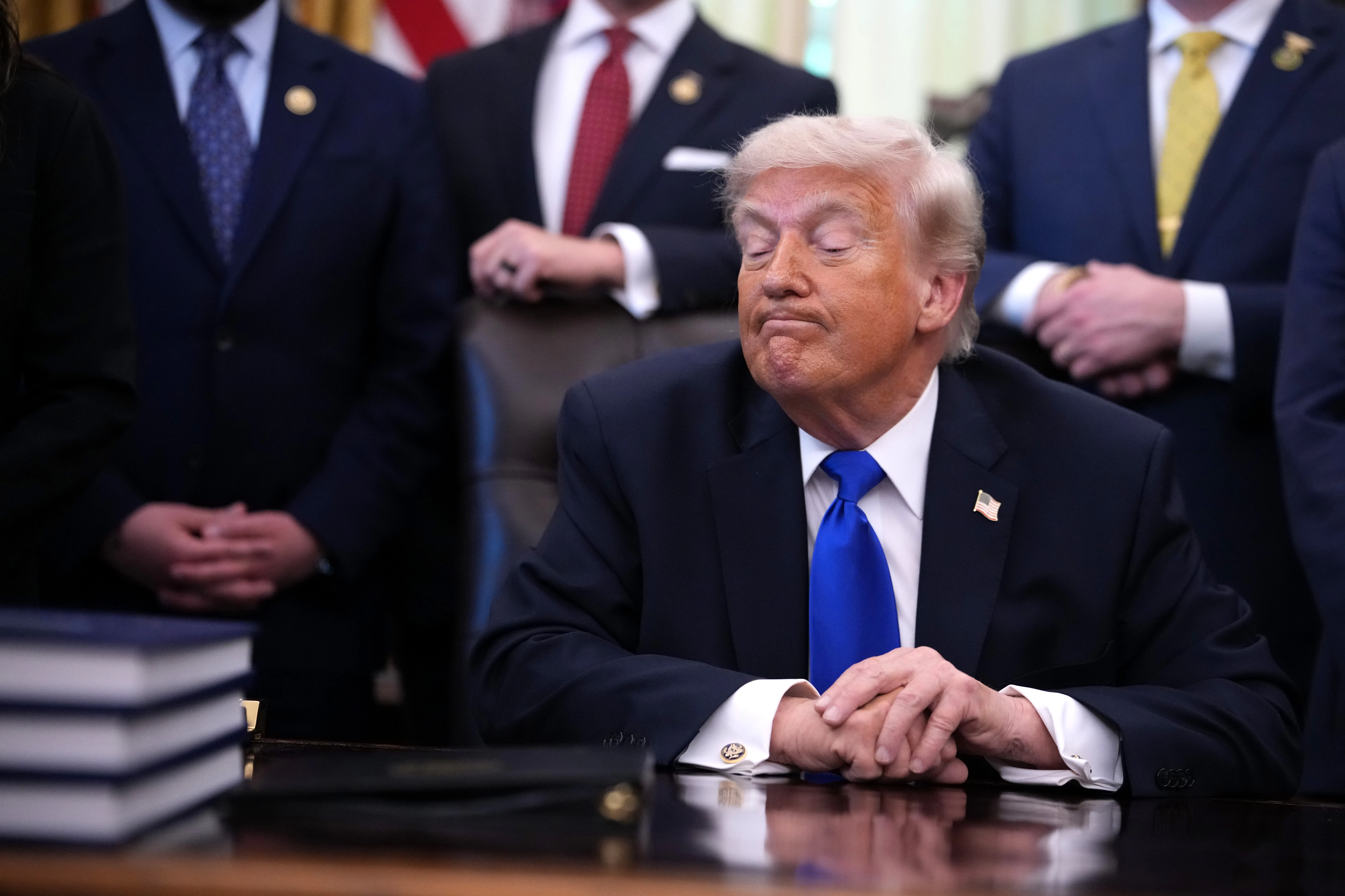 Donald Trump makes a weird face while sitting at his desk in the Oval Office