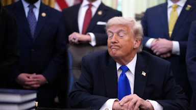 Donald Trump makes a weird face while sitting at his desk in the Oval Office