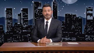 Jimmy Kimmel sits behind his late night desk