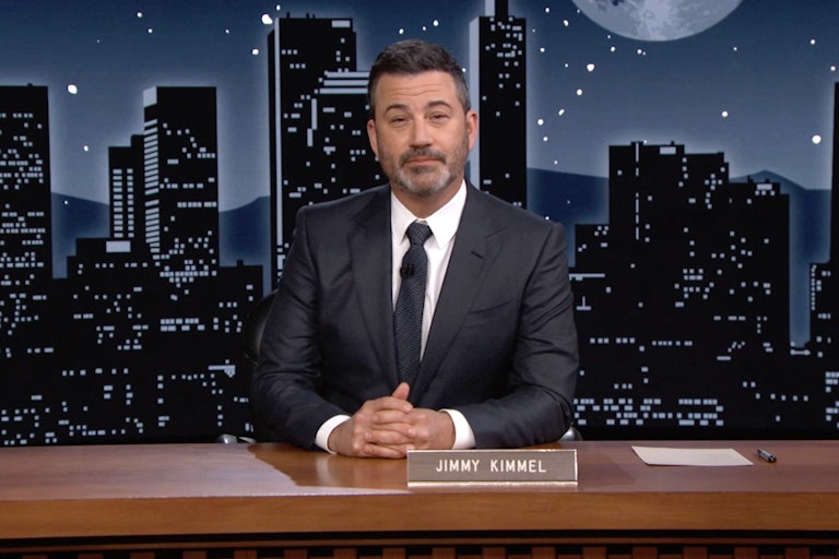 Jimmy Kimmel sits behind his late night desk