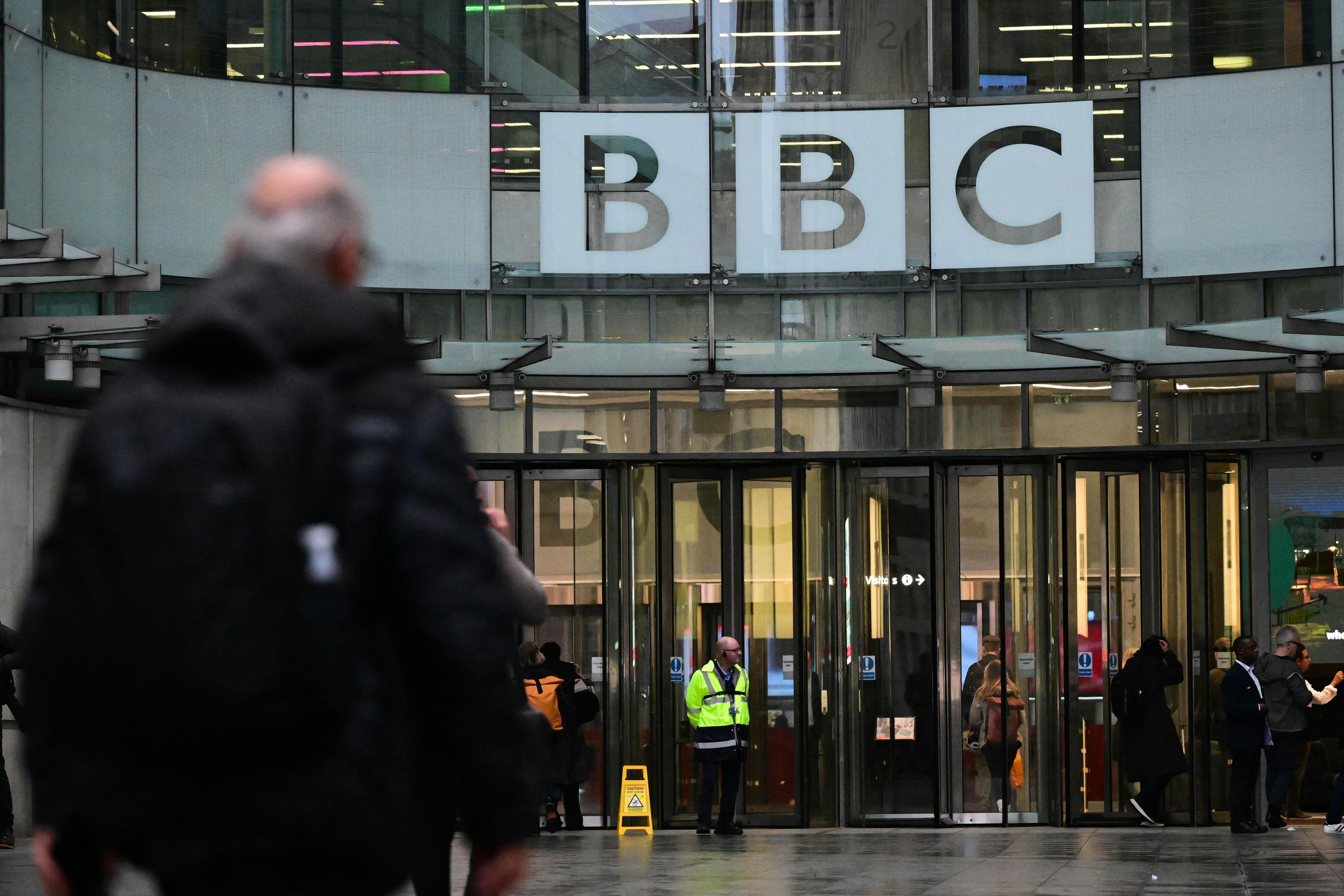 A man walks in front of the BBC headquarters.